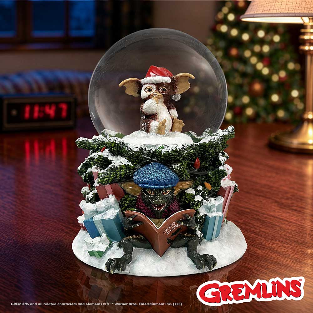 Gremlins Christmas Carol Snow Globe - Gremlins Christmas globe displayed beside festive lights