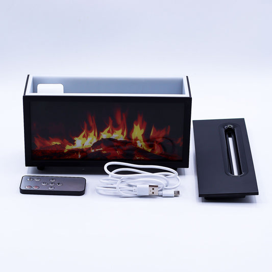 Black rectangular tabletop electric fireplace shows glowing simulated flames while a remote, USB cable, and burner insert lie in front on a white surface against a plain studio background.