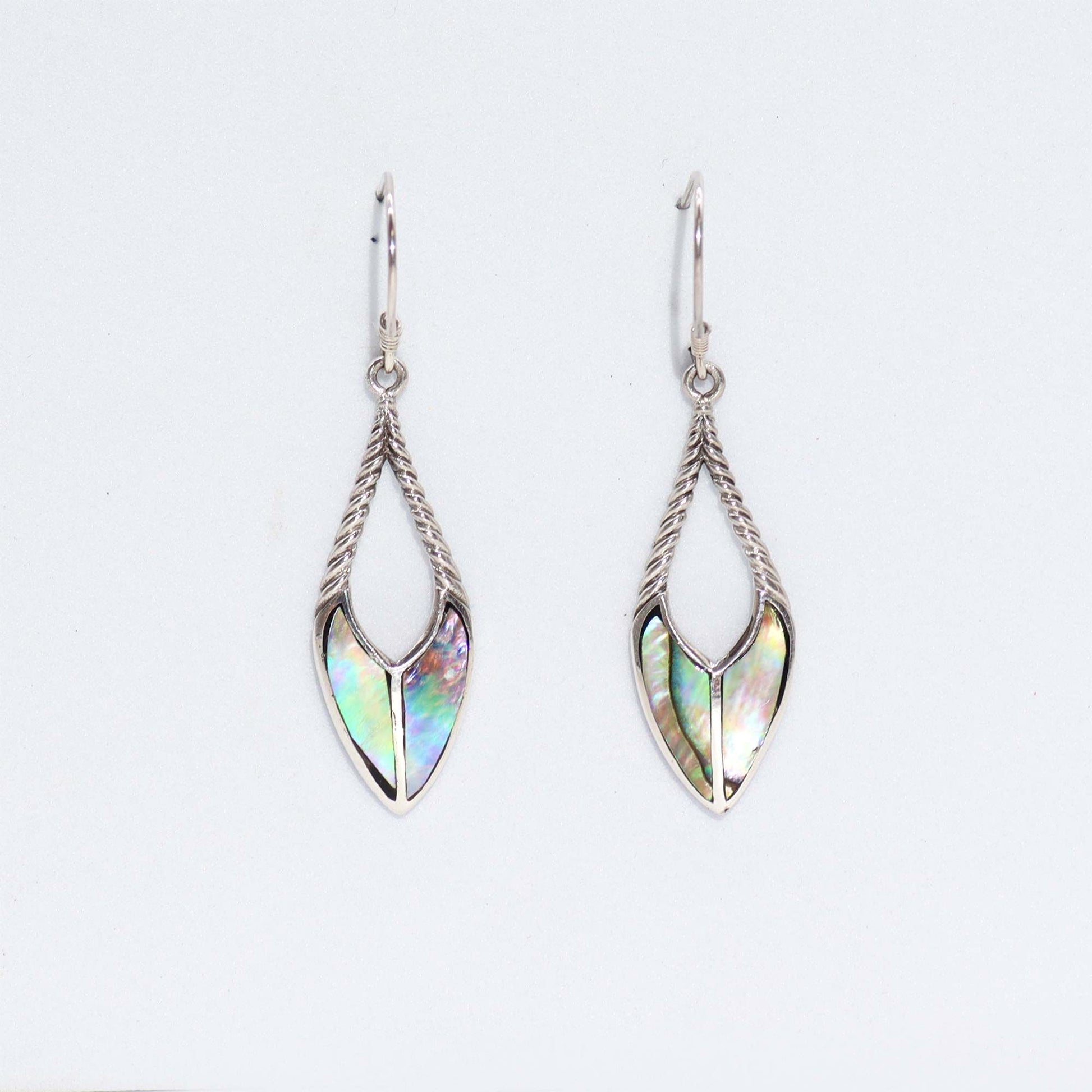 Pair of silver teardrop earrings hang against a plain white background, twisted rope frames holding iridescent abalone shell inlays.
