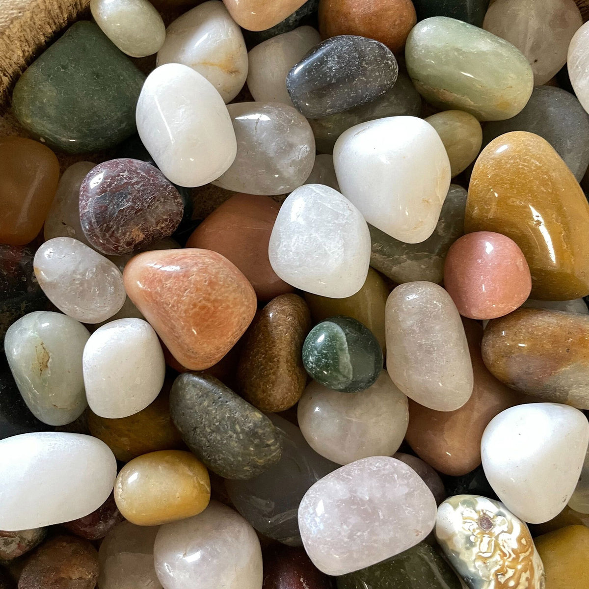 Bag of assorted polished mixed gemstone tumblestones in various colours and sizes.