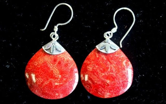 Pair of polished red marbled teardrop earrings with silver petal accented caps and shepherd hook ear wires resting on black velvet background.
