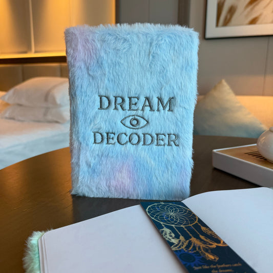 Soft pastel Dream Decoder journal with embroidered all-seeing eye and silver lettering on plush faux-fur cover