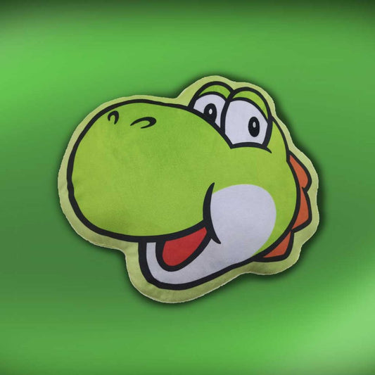 A plush pillow depicting a cartoon dinosaur's head, smiling with wide eyes and an open mouth, set against a solid green background.