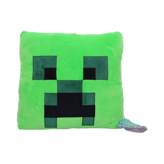 A square, green plush pillow features a pixelated black face resembling Minecraft's Creeper; a tag reads “Minecraft,” indicating its association with the game. The background is plain white.