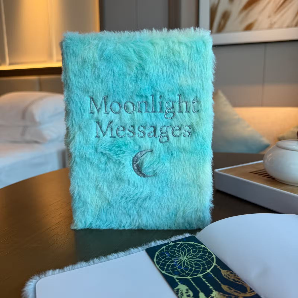 Pale green plush Moonlight Messages dream journal with silver celestial detailing and crescent moon design