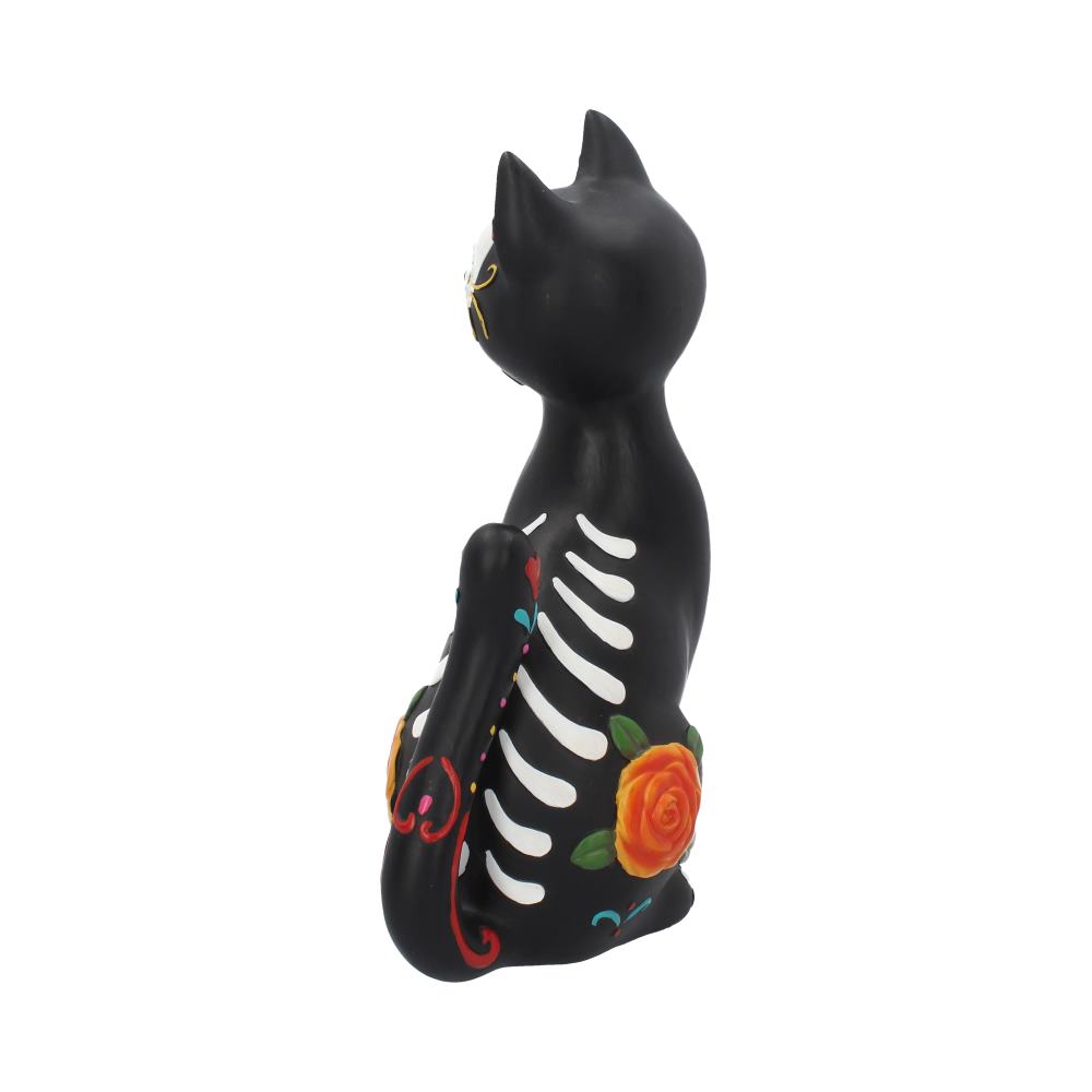A black cat figurine, decorated with colorful Day of the Dead motifs and floral patterns, sits upright, facing left. Its body displays painted bones, set against a plain white background.