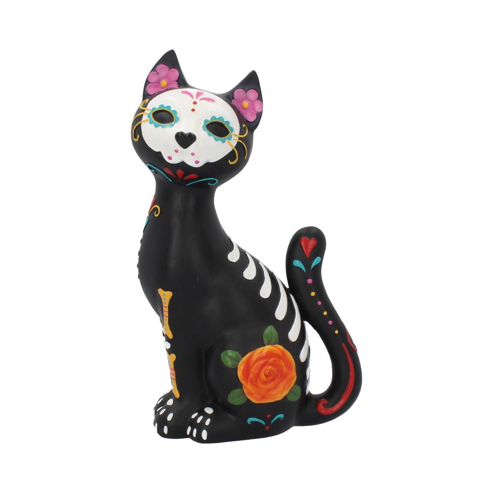A black ceramic cat figurine, adorned with colorful Día de los Muertos-style decorations like flowers and skeleton patterns, sits upright against a white background.
