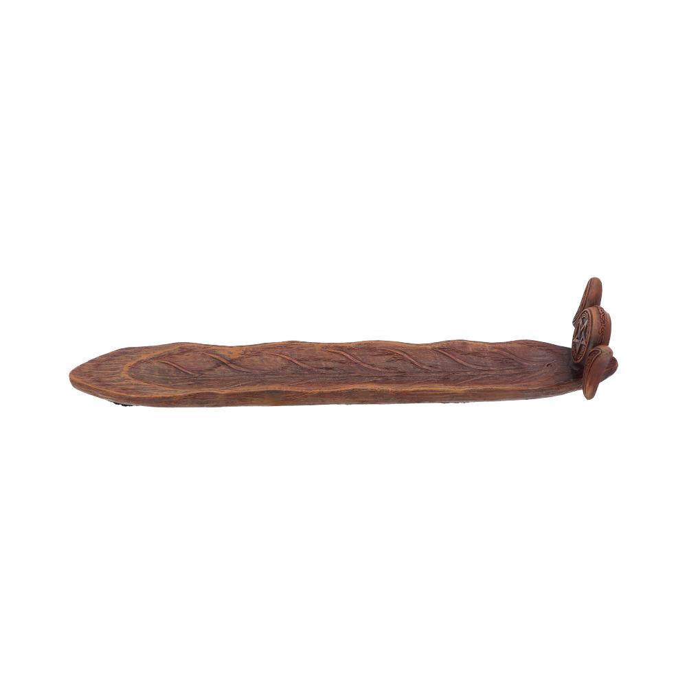 A carved wooden tray rests on a plain white background.  The tray is long and narrow with a textured surface and decorative carvings at one end.