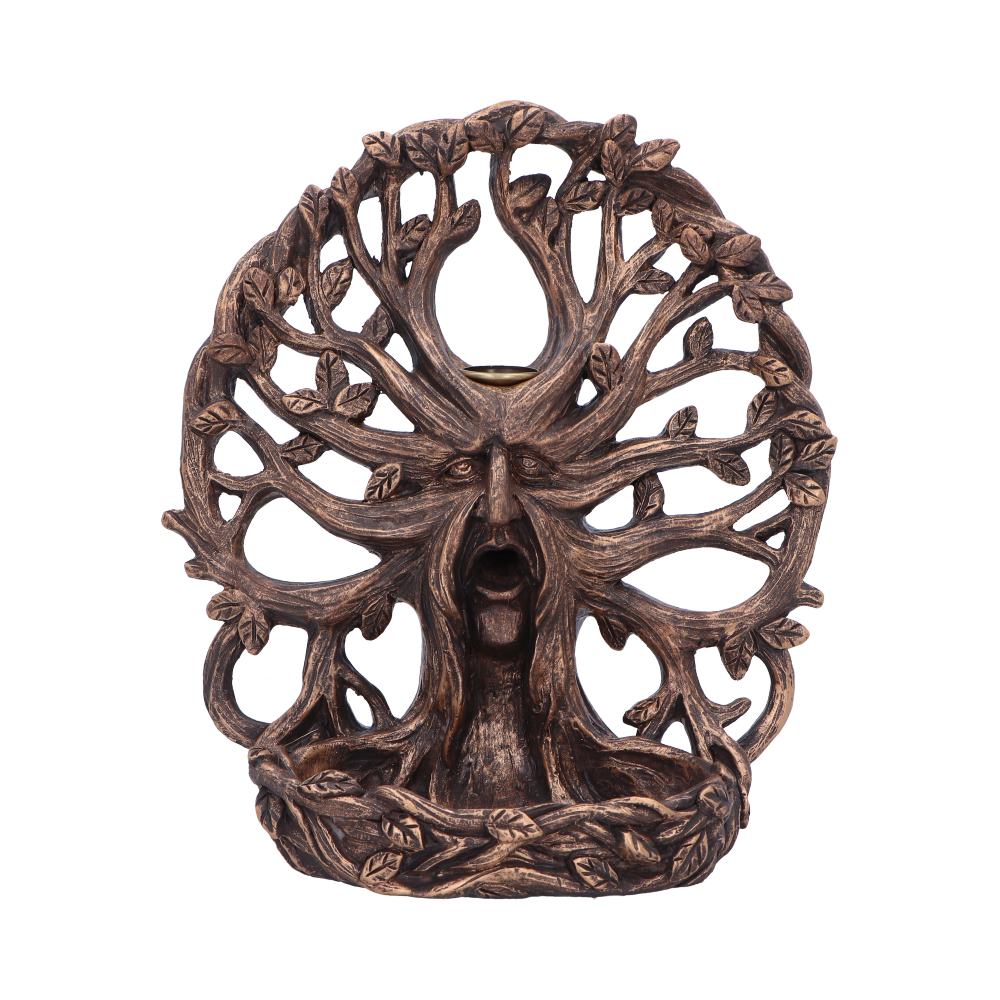 A wooden sculpture depicts a face with an open mouth, intertwined with detailed branches and leaves, creating an intricate tree-like form against a plain background.