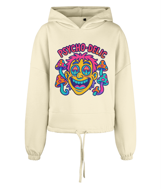 Cream cropped hoodie displaying text "PSYCHO-DELlC" above a colorful cartoon face with droopy eyes and surrounding spotted mushrooms on a plain black background.