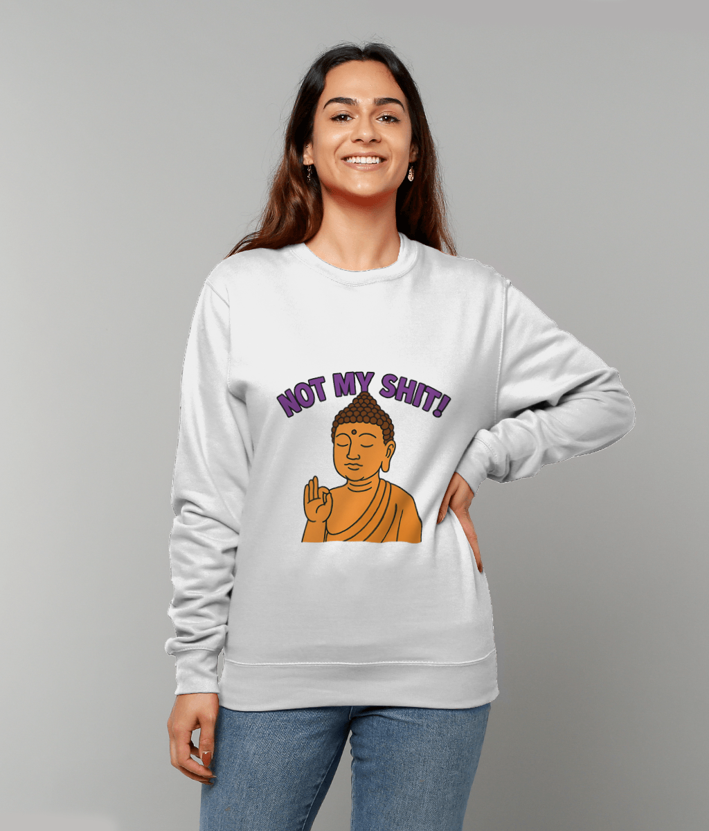 White sweatshirt displays orange cartoon Buddha raising a hand with purple text reading "NOT MY SHIT!" worn by a smiling person against a plain gray background.