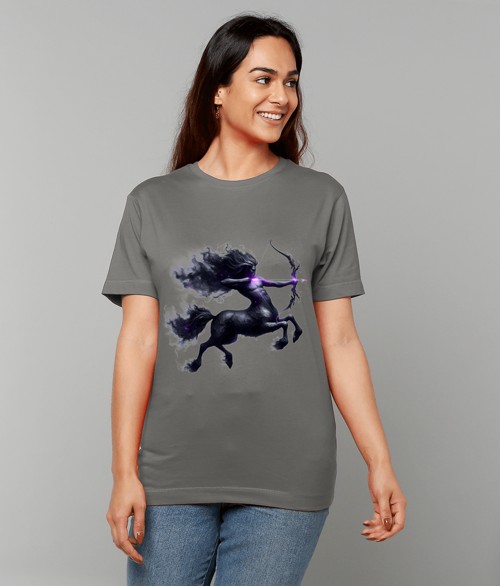 T-shirt displaying a dark cosmic centaur archer drawing a glowing purple arrow while a smiling woman wears it standing against a plain gray backdrop and blue jeans.
