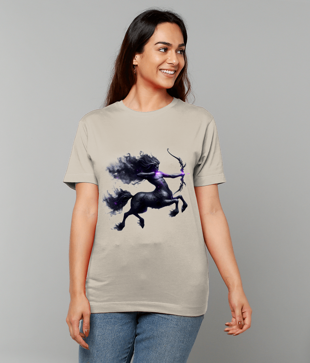 Woman wearing a beige T-shirt displays a dark centaur archer graphic rearing and drawing a glowing purple bow centered on the shirt against a plain gray studio background.