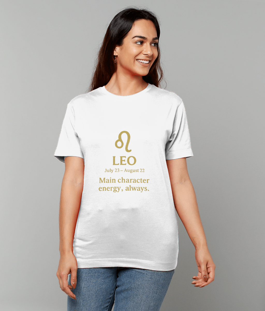 T-shirt with a gold Leo symbol worn by a smiling woman standing against a plain gray background; text on shirt reads "LEO July 23 – August 22 Main character energy, always."