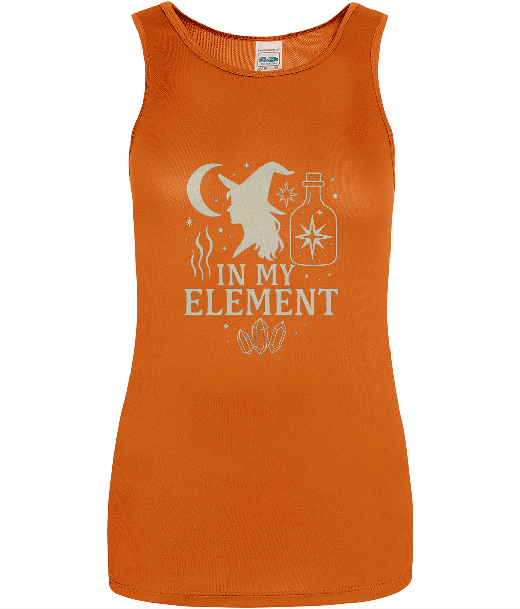 Tank top displays witch silhouette, crescent moon, potion bottle, crystals and stars arranged above the text "IN MY ELEMENT" printed on an orange background.