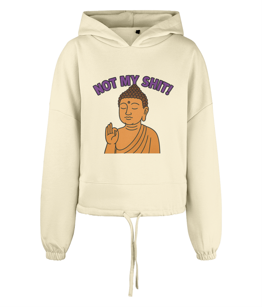 Cream hooded sweatshirt displays a centered cartoon Buddha raising a hand in blessing and the text "NOT MY SHIT!" arched above, photographed against a plain black background.