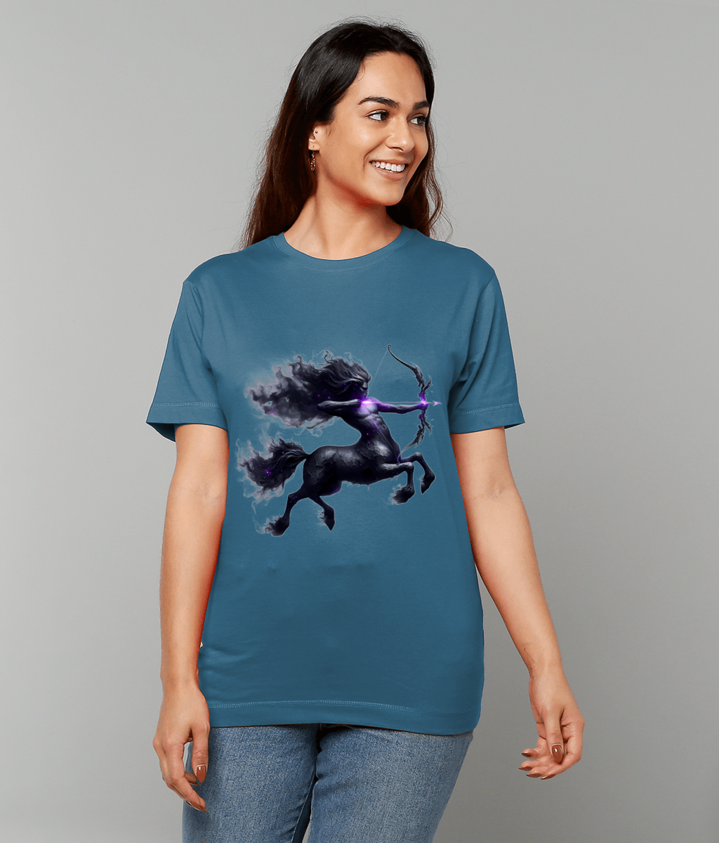 A dark purple centaur archer graphic draws a glowing bow on a teal T-shirt worn by a smiling woman standing against a plain gray background.