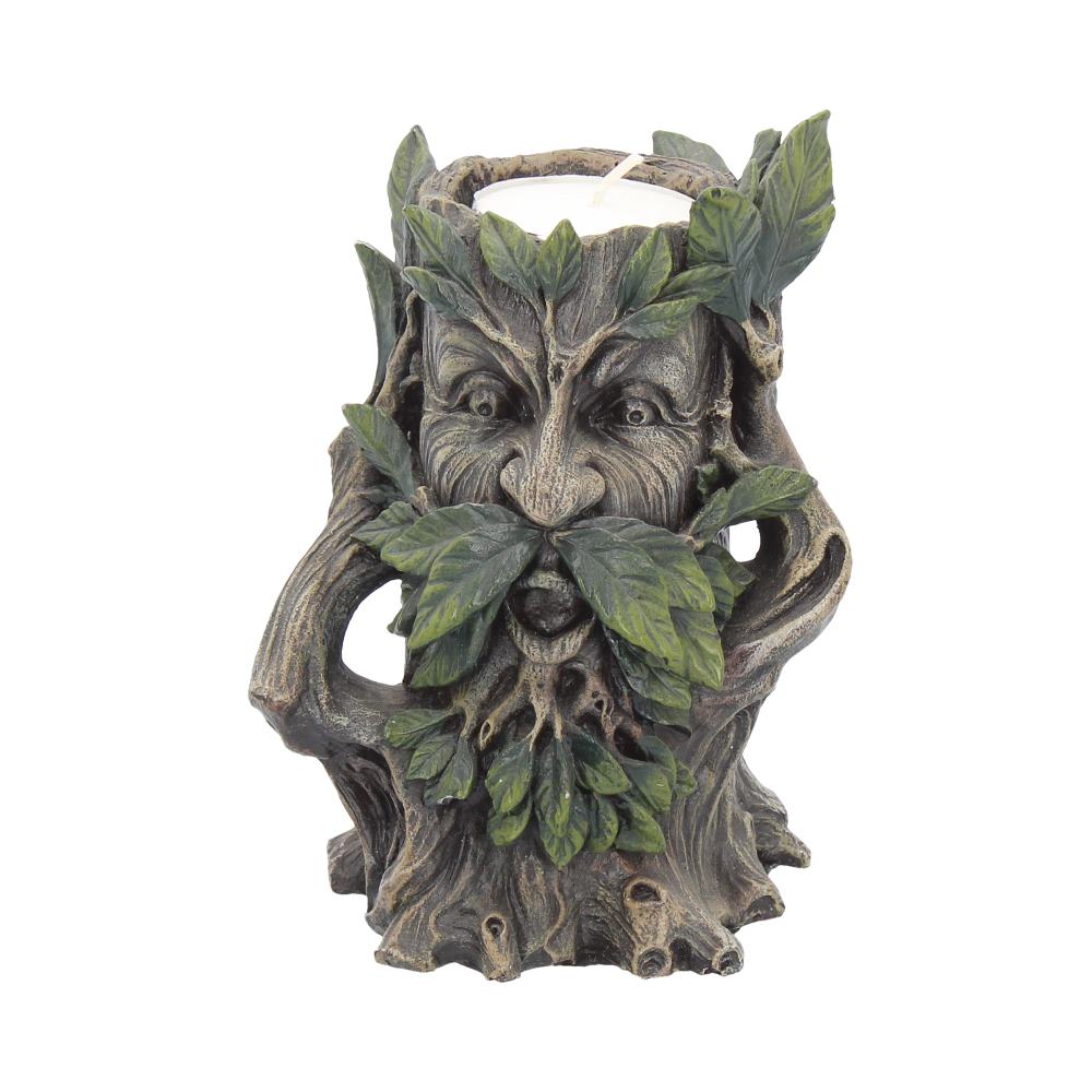 A "Green Man" candle holder supports a white candle; the holder is a tree stump with a face of a man made of leaves and bark. The background is white.