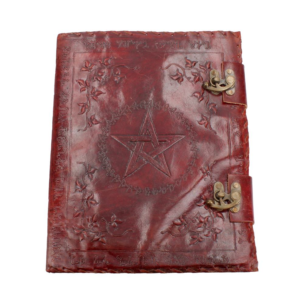 A red leather journal lies closed, displaying a central pentagram surrounded by a floral wreath. The journal also features two metal clasps and text bordering the other three sides of the cover.