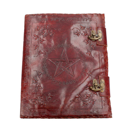 A red leather journal lies closed, displaying a central pentagram surrounded by a floral wreath. The journal also features two metal clasps and text bordering the other three sides of the cover.