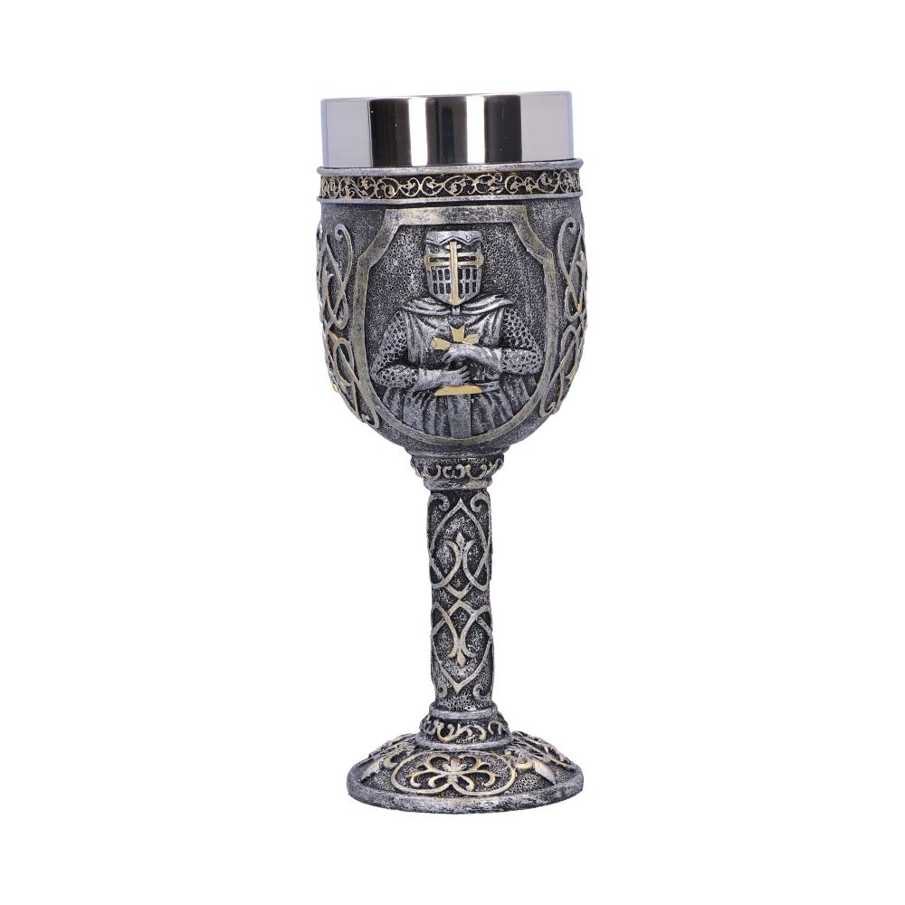A decorative silver goblet stands on a white surface. It's detailed with a medieval knight figure, and the stem and base have intricate designs.