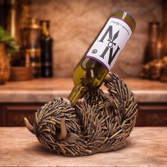Gold Highland Cow Guzzler Wine Holder - shown holding a wine bottle at an angle in a warm interior setting