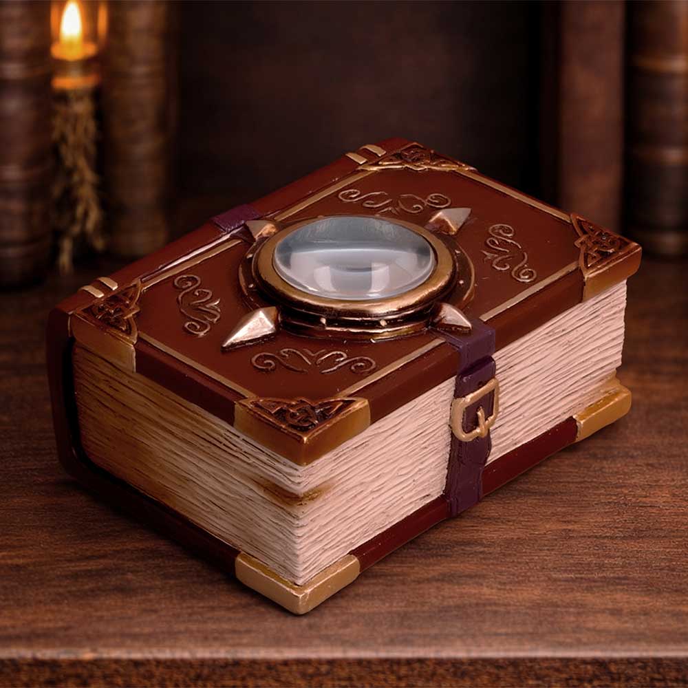Hidden Hoard Book Trinket Box - displayed on a wooden surface with the eye-decorated book cover facing up